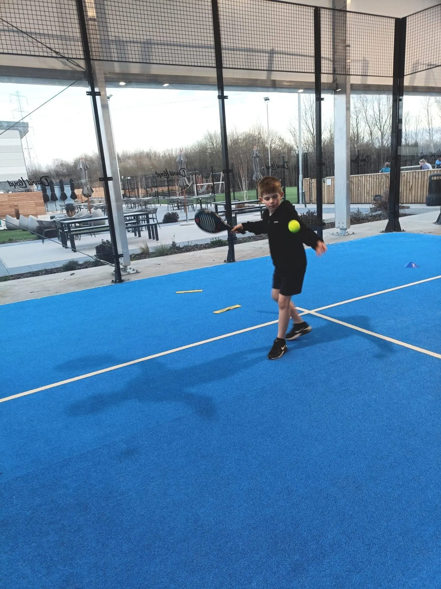 A junior player hitting a forehand