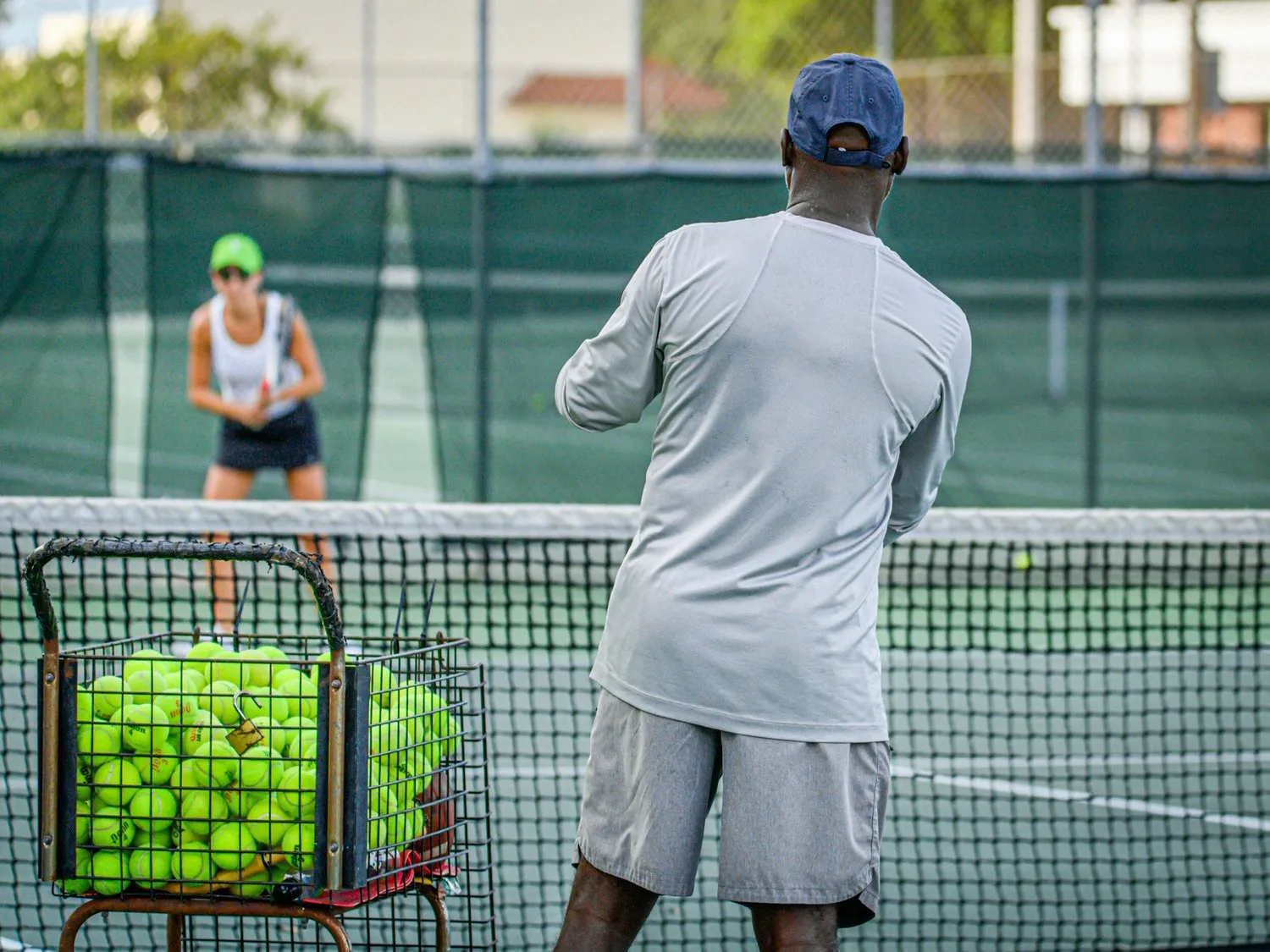 NJ feeding balls during a tennis lesson